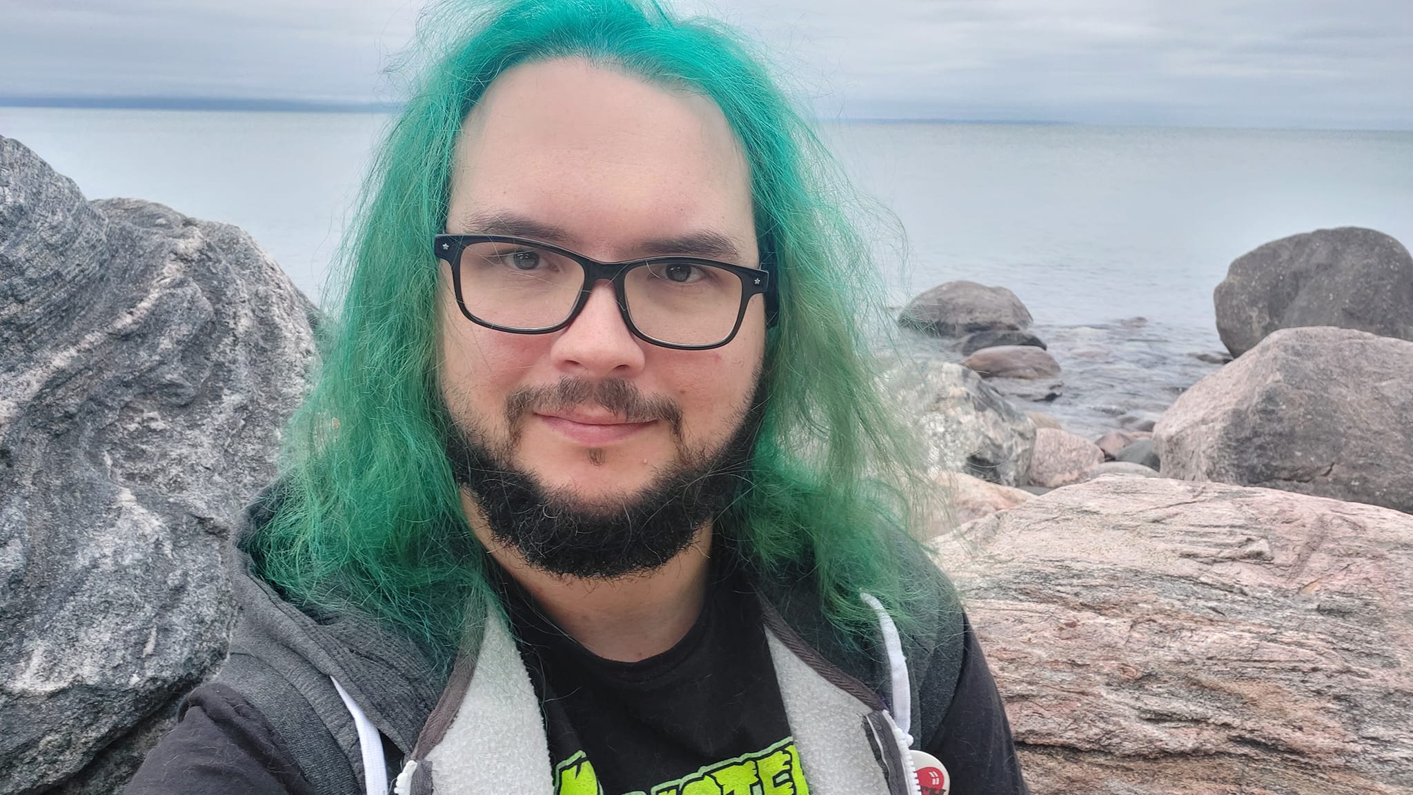 A man with green hair stands outside at a boulder breakwater, photo 19